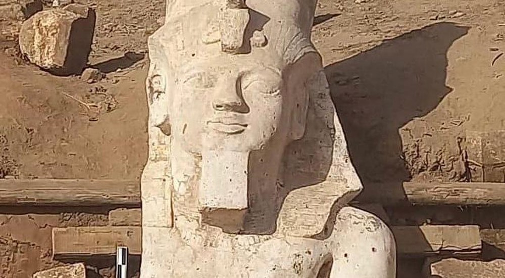 uncovering the upper part of a colossal statue of King Ramses II